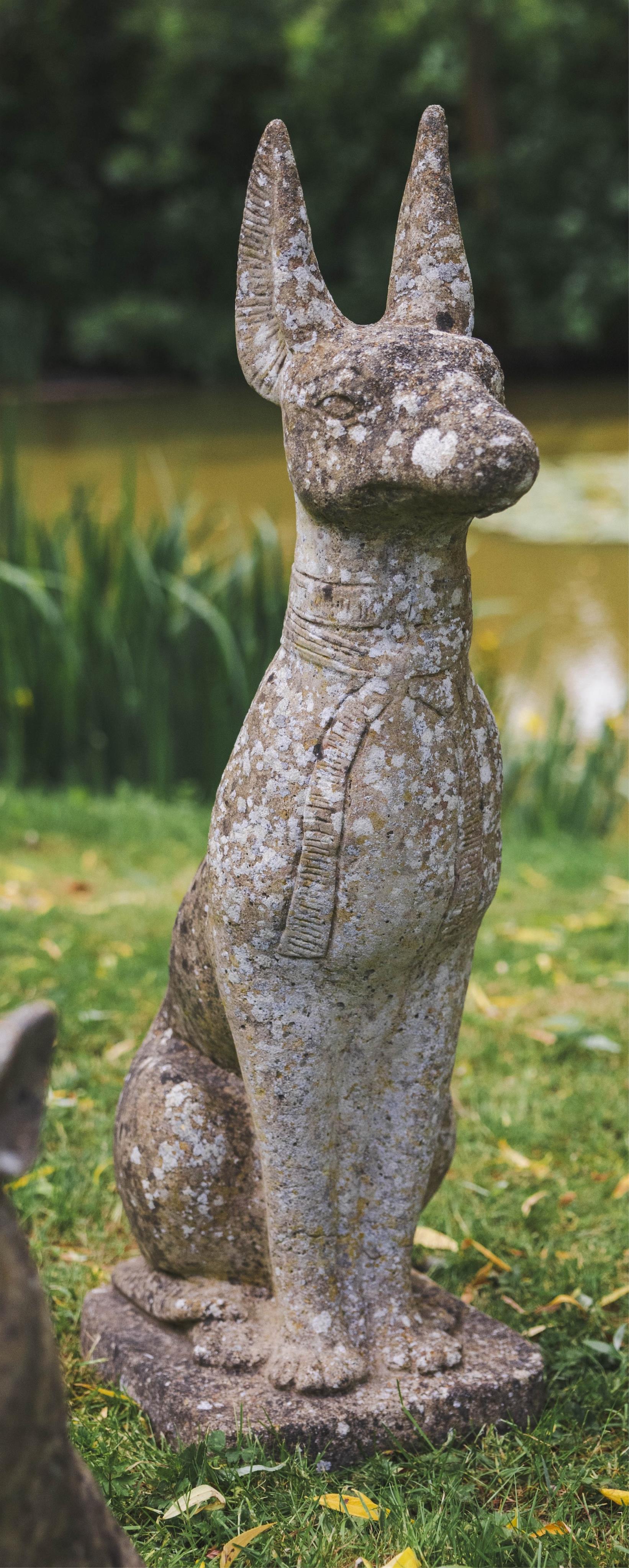 A reconstituted stone seated Anubis garden ornament, height 86cm